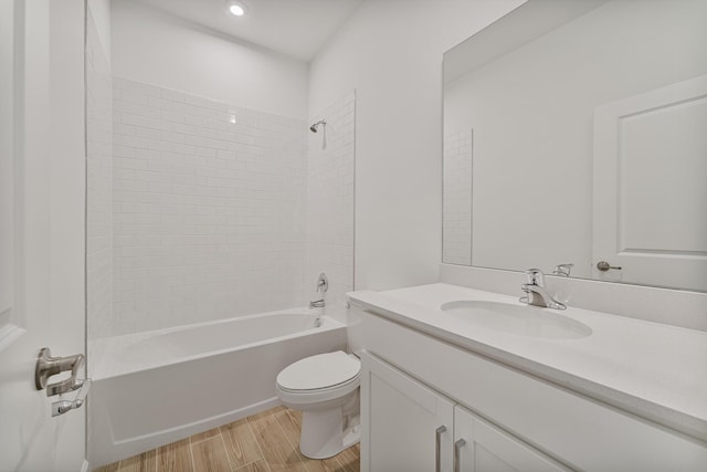 full bathroom featuring tiled shower / bath combo, vanity, hardwood / wood-style flooring, and toilet