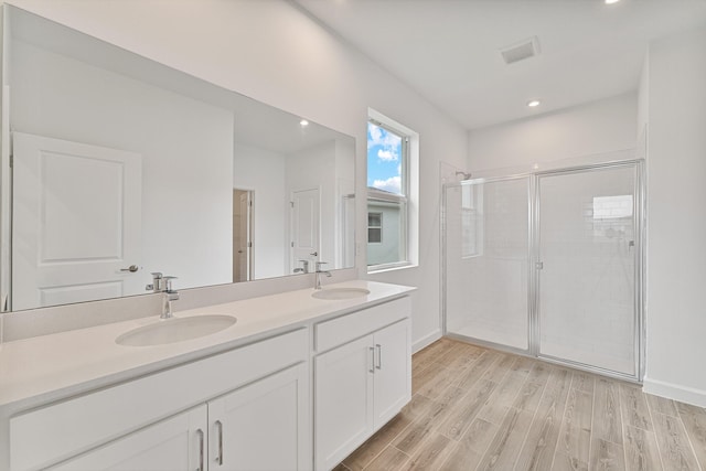 bathroom with vanity, hardwood / wood-style flooring, and a shower with door