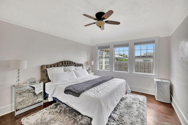 bedroom with dark wood-type flooring, ceiling fan, and a textured ceiling