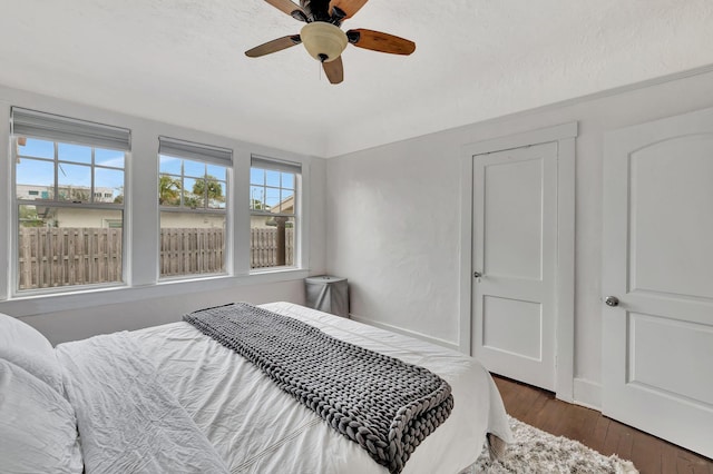 bedroom with ceiling fan and dark hardwood / wood-style flooring