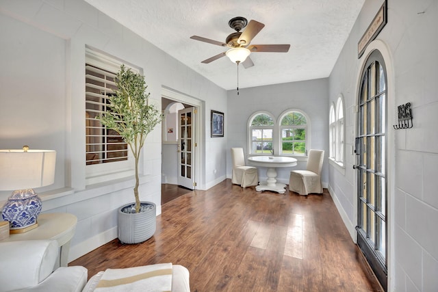 sitting room featuring ceiling fan, dark hardwood / wood-style flooring, and a textured ceiling