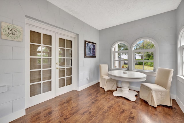 dining room featuring french doors, dark hardwood / wood-style flooring, and a textured ceiling