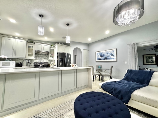 kitchen featuring sink, white cabinetry, pendant lighting, stainless steel appliances, and decorative backsplash