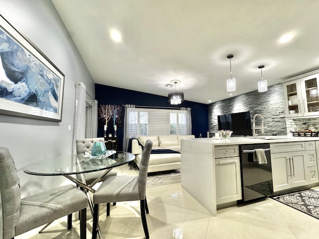 kitchen with pendant lighting, sink, black dishwasher, backsplash, and light tile patterned floors