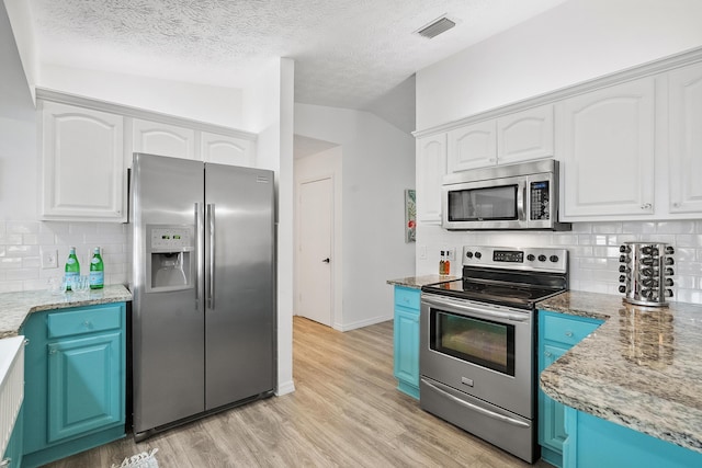 kitchen featuring stainless steel appliances, visible vents, white cabinetry, blue cabinetry, and light wood-type flooring