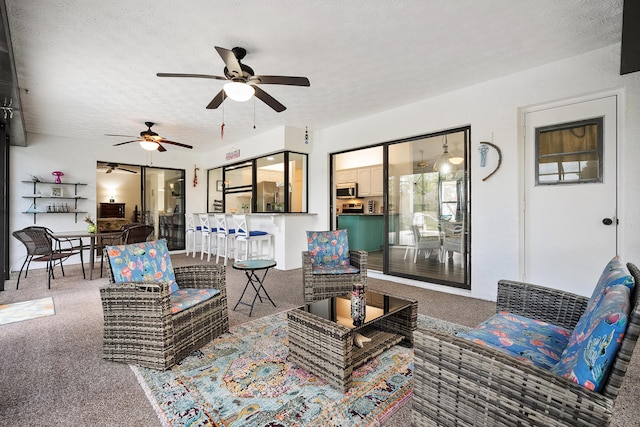 view of patio / terrace featuring outdoor dining area, an outdoor hangout area, and a ceiling fan