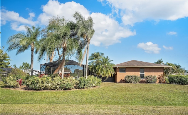 view of front of property featuring a lanai, a front lawn, and stucco siding