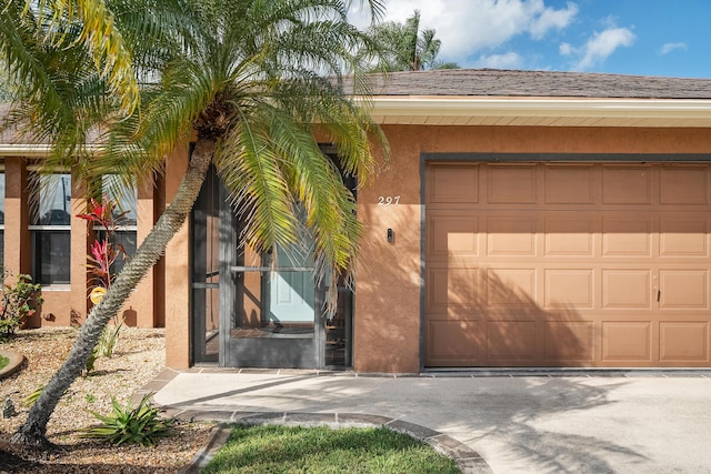 exterior space featuring a garage, roof with shingles, and stucco siding