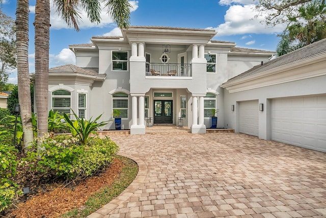 view of front of house with a garage, a balcony, and french doors