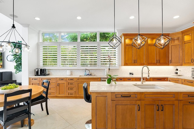 kitchen with crown molding, decorative light fixtures, light tile patterned flooring, and sink