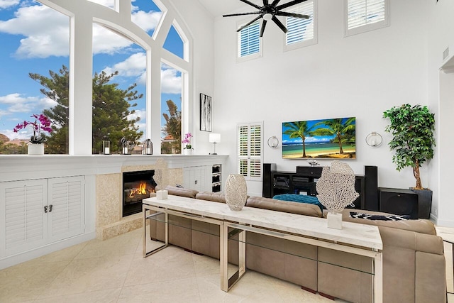 tiled living room with a healthy amount of sunlight, a fireplace, and a high ceiling