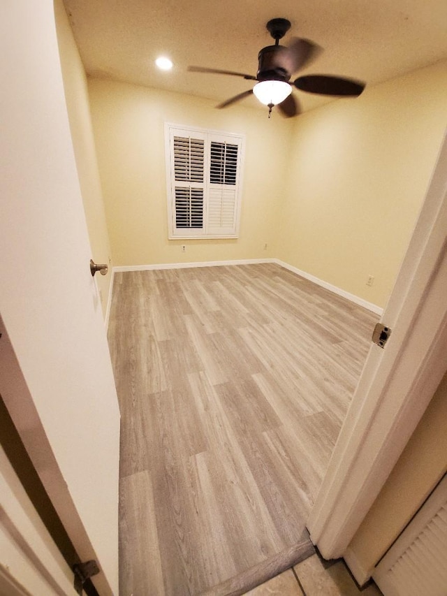 unfurnished room with ceiling fan and light wood-type flooring