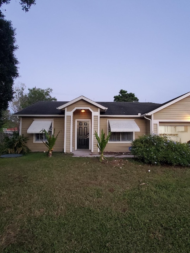 ranch-style home featuring a front lawn