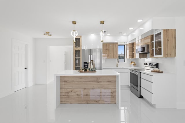 kitchen featuring white cabinetry, stainless steel appliances, sink, and a kitchen island