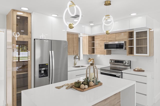 kitchen featuring white cabinetry, appliances with stainless steel finishes, and pendant lighting