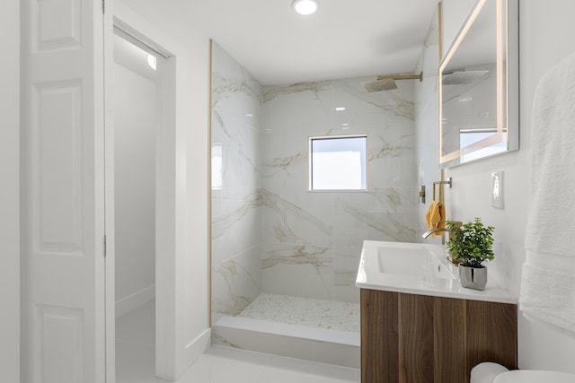 bathroom with vanity and a tile shower