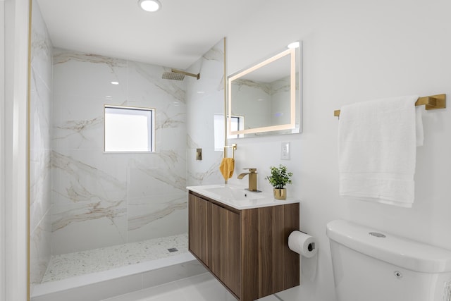 bathroom featuring vanity, tiled shower, and toilet