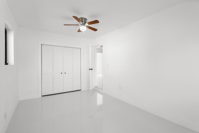 unfurnished bedroom with ceiling fan and a closet