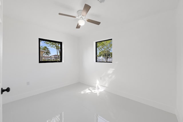 spare room featuring ceiling fan and a healthy amount of sunlight