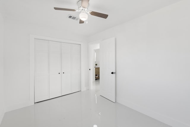 unfurnished bedroom with ceiling fan and a closet