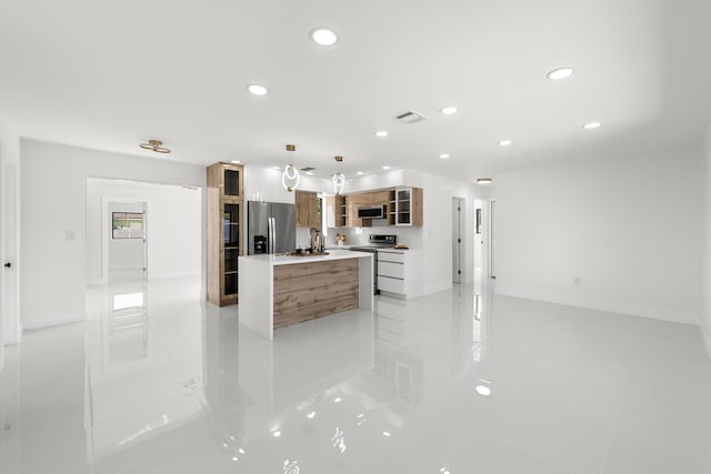 kitchen featuring light tile patterned flooring, pendant lighting, sink, a center island, and stainless steel appliances