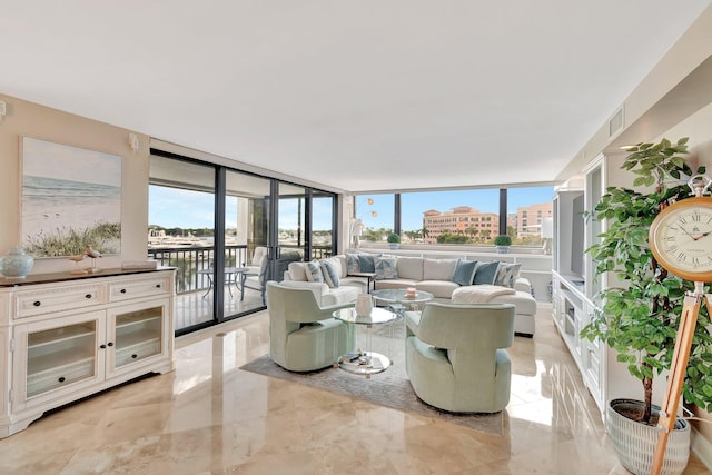 living room with a wealth of natural light, visible vents, and marble finish floor