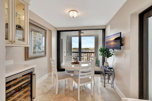 dining room featuring beverage cooler and baseboards