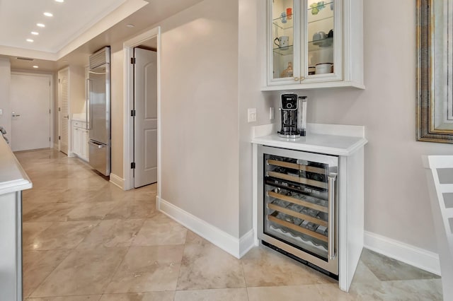 bar with recessed lighting, beverage cooler, baseboards, and stainless steel built in refrigerator