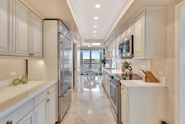 kitchen with stainless steel appliances, recessed lighting, light countertops, and a sink