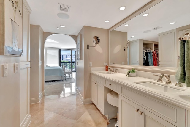 bathroom with double vanity, a sink, and visible vents