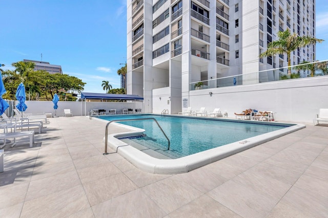 pool featuring fence and a patio