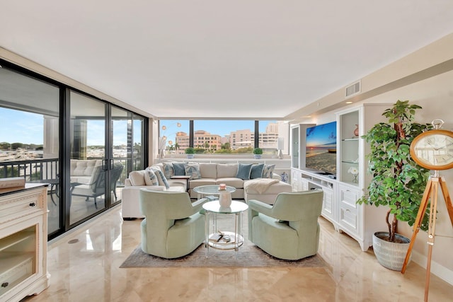 living area featuring expansive windows, marble finish floor, visible vents, and a healthy amount of sunlight