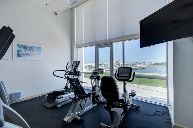 exercise room featuring a water view