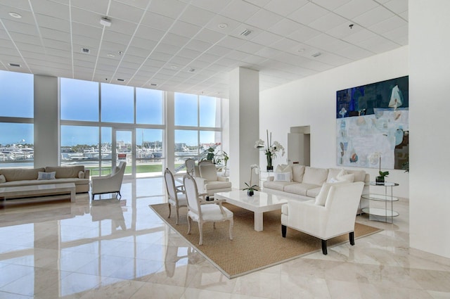 living room with expansive windows, a high ceiling, visible vents, and a paneled ceiling