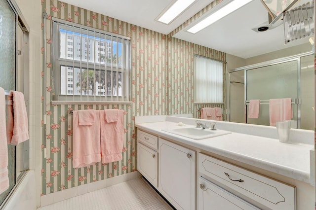 bathroom with vanity, tile patterned flooring, and combined bath / shower with glass door