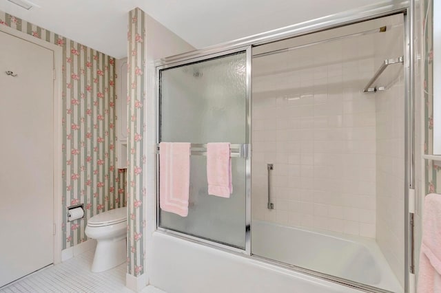 bathroom featuring bath / shower combo with glass door, toilet, and tile patterned flooring