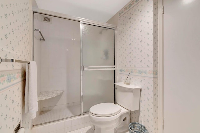 bathroom with walk in shower, toilet, and tile patterned flooring