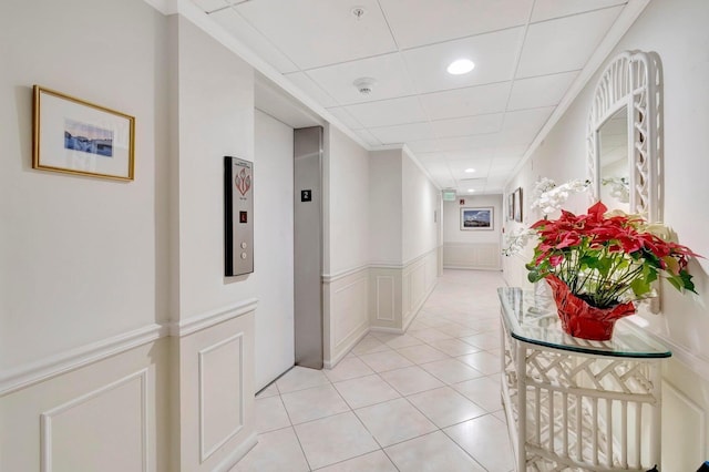 hallway featuring a drop ceiling and light tile patterned floors