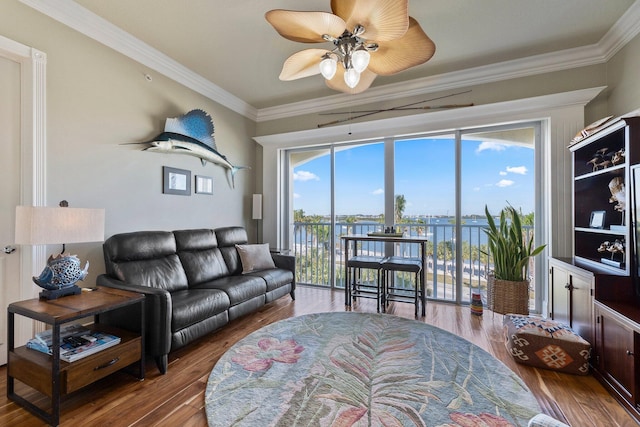 living room with a water view, ceiling fan, ornamental molding, and hardwood / wood-style flooring