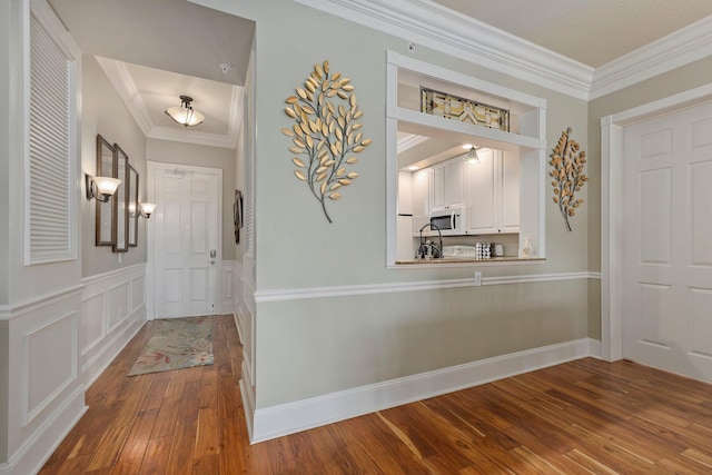 entryway featuring wood-type flooring and ornamental molding