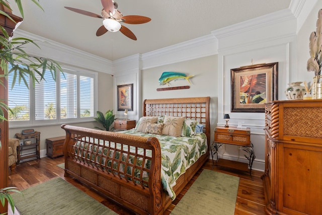 bedroom with dark hardwood / wood-style flooring, crown molding, and ceiling fan