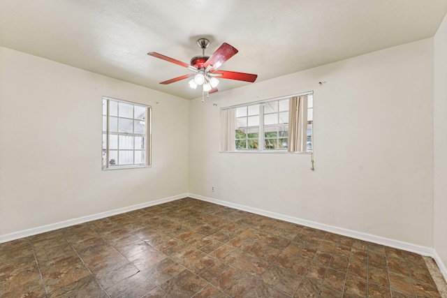 empty room featuring ceiling fan and plenty of natural light