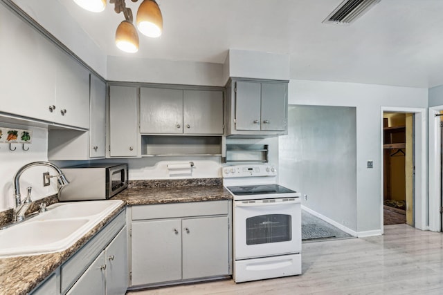 kitchen featuring electric stove, sink, light hardwood / wood-style flooring, and gray cabinetry