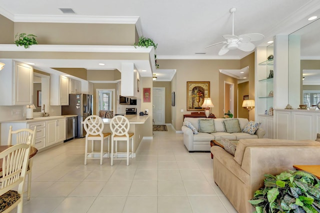 living room featuring ornamental molding, sink, light tile patterned floors, and ceiling fan