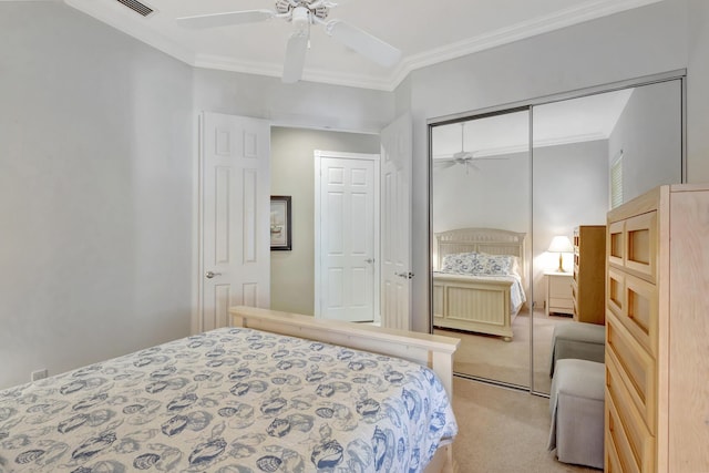 bedroom featuring light carpet, crown molding, a closet, and ceiling fan