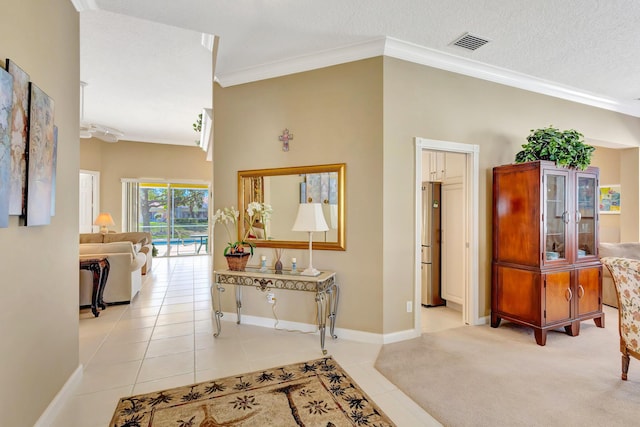 corridor featuring light tile patterned flooring, crown molding, and a textured ceiling