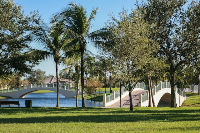 surrounding community with a lawn and a water view