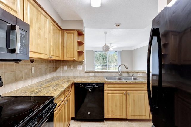 kitchen with sink, decorative backsplash, ceiling fan, black appliances, and light stone countertops