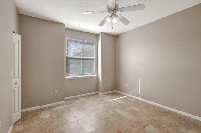 spare room featuring light tile patterned flooring, a textured ceiling, and ceiling fan