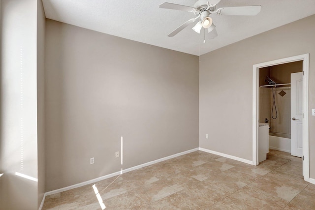 unfurnished bedroom with a walk in closet, a closet, and ceiling fan